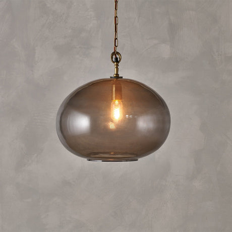 Otoro Large Round Recycled Glass Pendant Light in Smoke, a flattened spherical glass shade with brass chain and collar, shown lit against a plain grey background.