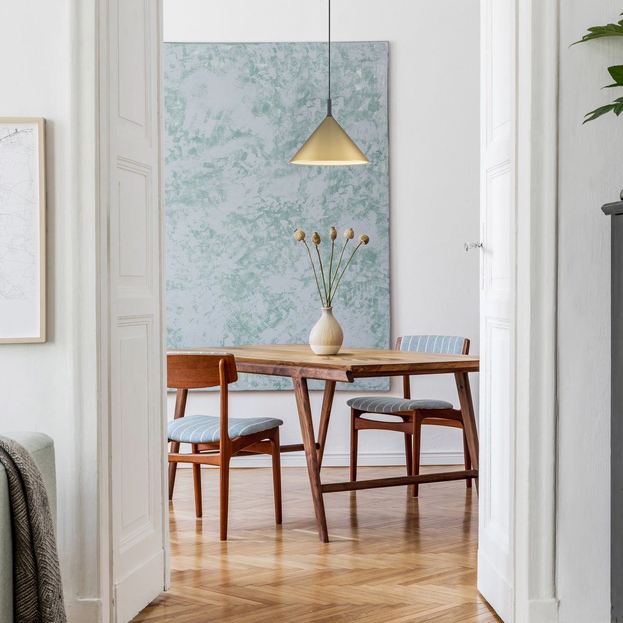 Joy pendant light in satin brass finish, shown in a room setting