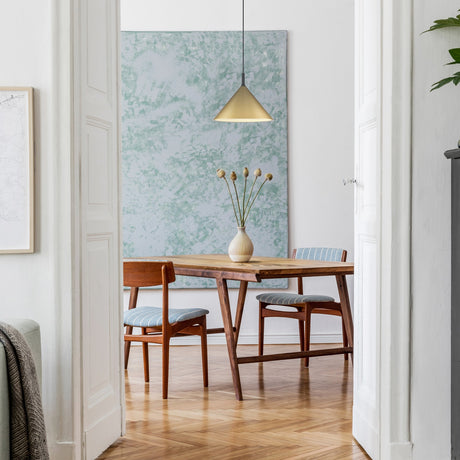 Joy pendant light in satin brass finish, shown in a room setting