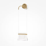 A modern wall-mounted towel holder with a minimalist design features a gold circular bracket and transparent hanging bar. The clean lines and brass-like finish echo the sophistication of the Cabaret LED Vertical Wall Light - Brass against a plain white background.