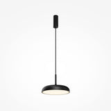 The Gerhard LED Dome Pendant Light 30cm - Black offers a contemporary black pendant with a flat, circular shade. Hung by a thin cable from a cylinder mount, it emits energy-efficient light that softly glows downward against the light gray backdrop.