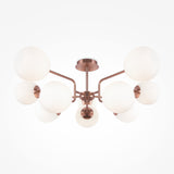Experience modern artistry with the Erich 10 Light Semi-Flush - Brass With White Glass, featuring a central base and multiple arms. Each arm supports a round white globe light against a plain white backdrop.