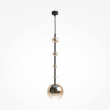 The Ros 1 Light Pendant features a black rod and five gold-tinted amber glass orbs in a minimalist design. These spherical shades increase in size from top to bottom, with the largest serving as the main light. Its sleek modern look suits any plain white setting perfectly.