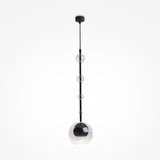 The Ros 1 Light Pendant features a black rod with five vertically arranged clear glass shades of varying sizes. The largest sphere at the bottom houses a bulb. This stylish fixture has an adjustable hanging length and hangs from a black ceiling mount against a white background.