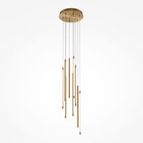 The Light Stick LED Dimmable Pendant - Brass features a sleek, minimal design with a round base and thin vertical rods of varying lengths. It fits perfectly in modern interiors, enhancing the brass finish against a white background for contemporary elegance.
