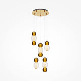 The Drop LED Cluster Pendant Light, 80W 3000K in Gold, features a modern circular metal frame with dangling bulbs encased in alternating clear and amber glass spheres. These energy-efficient bulbs hang at various heights, creating a striking cascading effect.