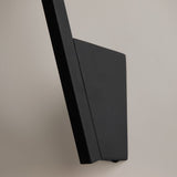 The sleek rectangular Kazimir Wall Light - Black With White Opal Glass is shown from the side against a light gray background, embodying minimalistic silhouettes and avant-garde artistry with its matte metal finish.