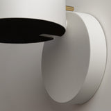 Close-up of the Nuance LED Movable Head Wall Light, featuring a modern minimalist design with a cylindrical white base and gold detailing. The image showcases the energy-efficient and textured design against a white background.