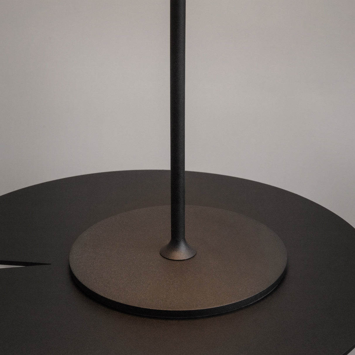 Close-up of a minimalist black AI Collaboration Rechargeable LED Table Lamp on a light gray background. The sleek, modern design features a round base and vertical pole, embodying contemporary style perfect for portable lighting needs.