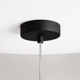 Close-up of the Duality Round Pendant Light featuring a black ceiling bracket and a silver rod, with dual mirrored gold glass shades. This modern industrial fixture is mounted on a white ceiling.