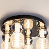 The Drop LED Flush Light 3000K - Chrome features multiple intricately patterned glass shades on a sleek chrome base, emitting warm ambient light to enhance contemporary spaces with style and elegance.
