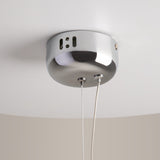 The Rebel LED Glass Pendant Light - Chrome features a sleek, circular design with a smooth, reflective surface and small rectangular cutouts. It hangs from two slender cables on a white ceiling.