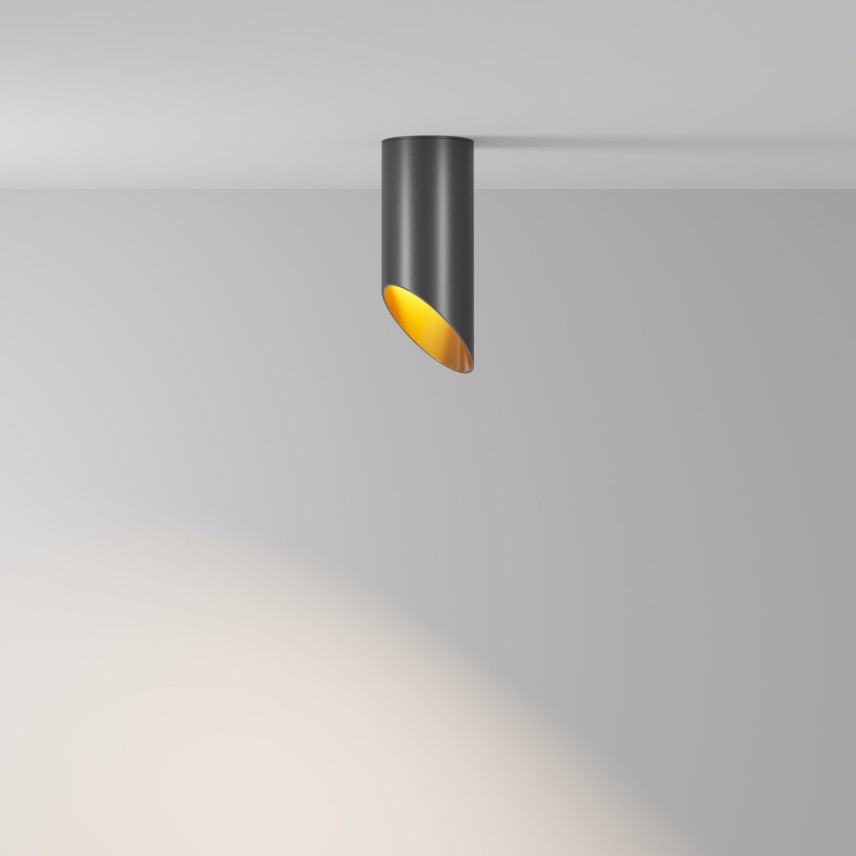 The Lipari Short Surface Mounted Downlight 15cm - Black & Gold has a sleek, cylindrical design that casts a warm glow on adjacent surfaces with its gold interior, adding an elegant touch to any rooms decor.