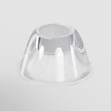 The Focus LED Track Light Lens, with a honeycomb pattern on clear textured glass, provides exquisite ambient lighting. It features a wide circular base narrowing to a smooth rim, set against a plain white background.