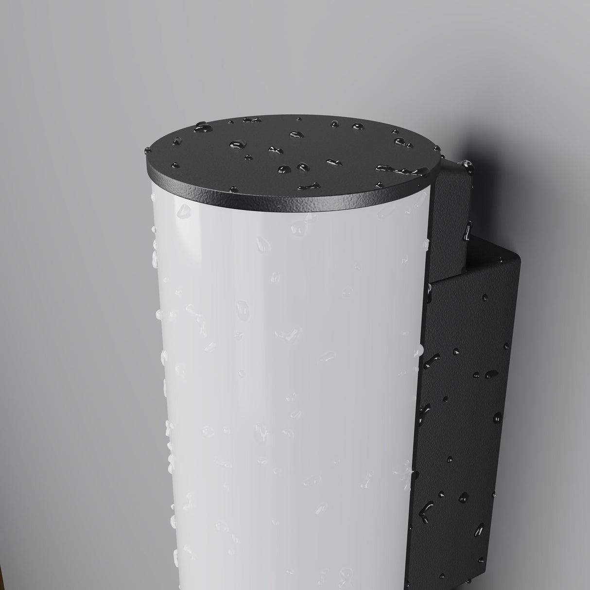 Close-up of a Rock Outdoor LED Wall Light 3000K - Graphite, glistening with raindrops. It showcases a white translucent front and a black metal backplate, mounted on a gray wall. Despite the weather, its energy-efficient LED shines brilliantly.