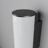 Close-up of a Rock Outdoor LED Wall Light 3000K - Graphite, glistening with raindrops. It showcases a white translucent front and a black metal backplate, mounted on a gray wall. Despite the weather, its energy-efficient LED shines brilliantly.