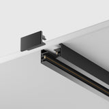 A close-up of the Unity Single Phase Surface-Mounted Track 1m in black, set against a white ceiling for customizable lighting. It shows the sleek black track with an exposed end cap, emphasizing its assembly components and modern finish.