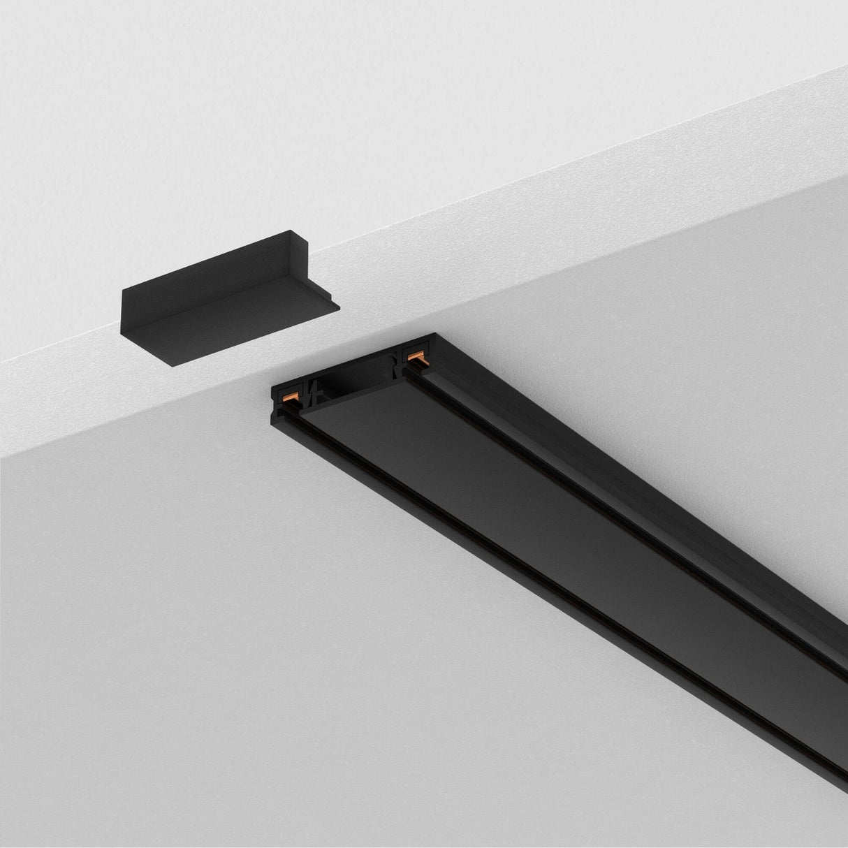 A close-up of the Radity Magnetic Surface-Mounted Track 2m in black against a white ceiling, ideal for modern interiors. One end is open, showing copper connectors, with a sleek black end cap nearby to complete this elegant lighting solution.