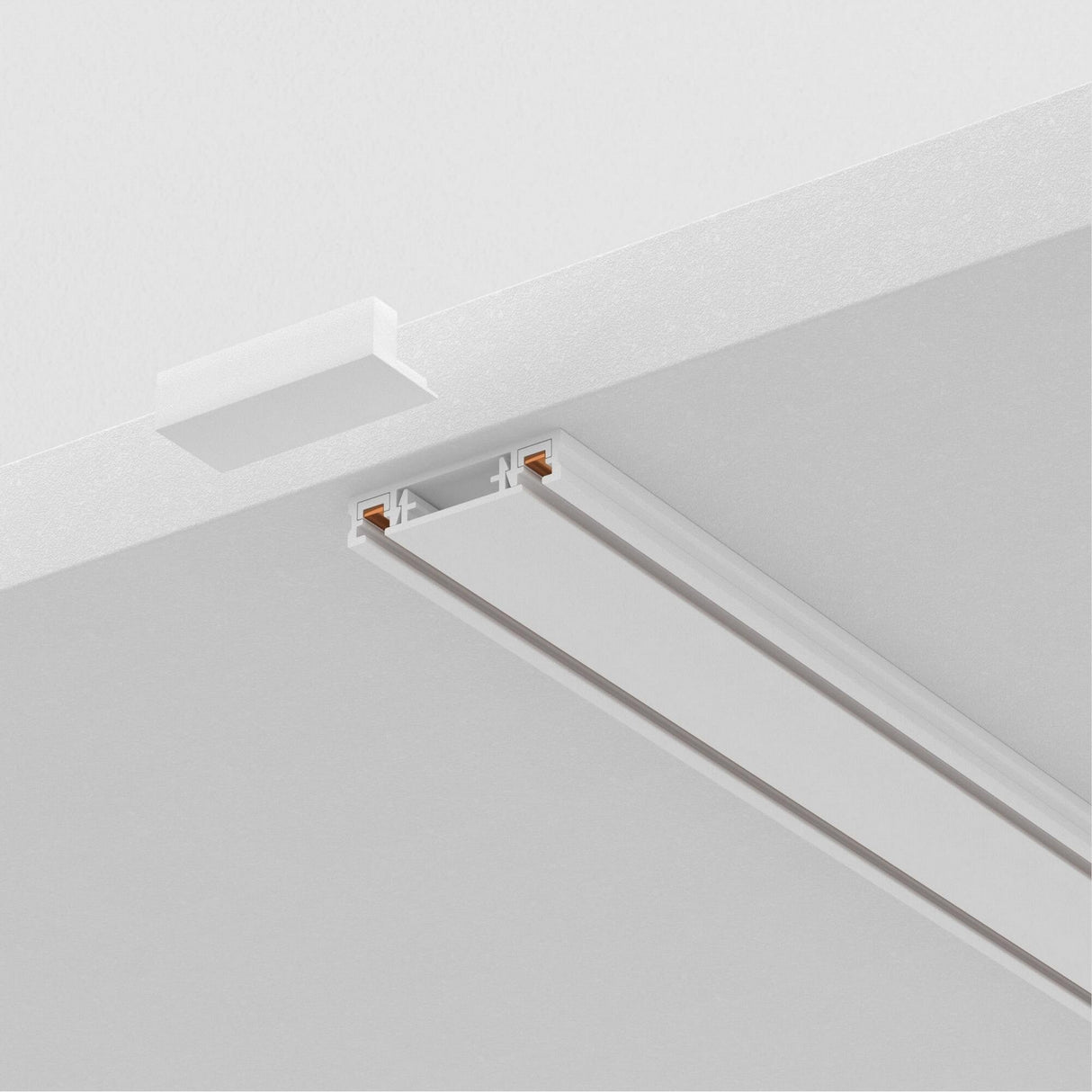 Close-up of a white ceiling with the Radity Magnetic Surface-Mounted Track 2m - White, ideal for modern interiors. This sleek linear fixture features a small rectangular opening for light installation on its magnetic track, with a partially visible white square panel nearby.