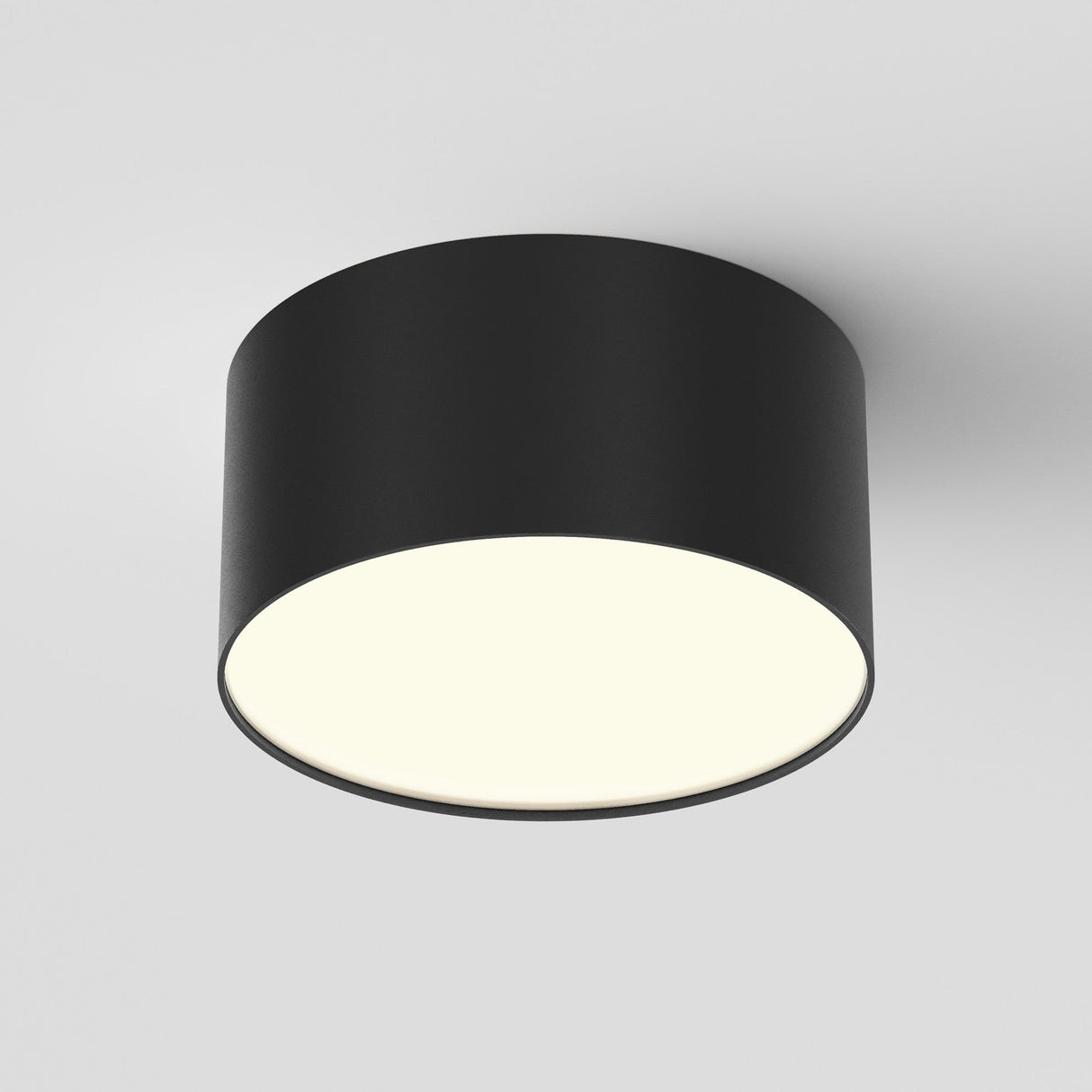 The Zon LED Downlight 3000K 12W in black features a modern circular design with a matte finish and provides bright ambient lighting, mounted seamlessly against a plain white ceiling for a minimalist aesthetic.