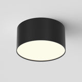 The Zon LED Downlight 3000K 12W in black features a modern circular design with a matte finish and provides bright ambient lighting, mounted seamlessly against a plain white ceiling for a minimalist aesthetic.