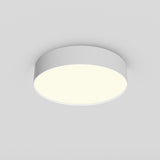 The Zon LED Small Flush Ceiling Light 3000K 36W - White is installed on a light gray ceiling. It emits a soft, even glow with its minimalist and modern design when turned on.