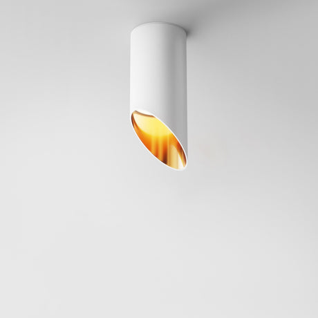 The Lipari Short Surface Mounted Downlight 15cm, with its white angled cylinder exterior and gold reflector, emits a warm glow that enhances a minimalist look on plain white ceilings.