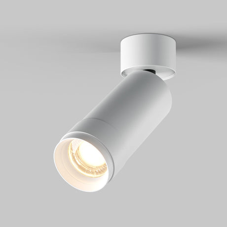 The Focus Zoom LED Single Surface-Mounted Spotlight 12W 3000K - White is a modern, cylindrical design spotlight mounted on a round base. It has an adjustable beam angle and illuminates with a warm glow against a light gray background.