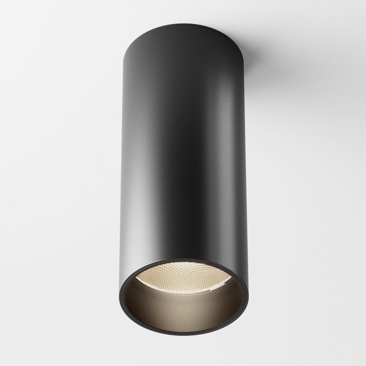 The Focus LED Dimmable Fixed Round Surface Mounted Downlight 12W 3000K - Black is a modern cylindrical black fixture on a white ceiling. Its open bottom reveals the LED light source, offering adaptable ambiance with dimmable downlighting.