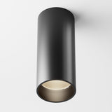 The Focus LED Dimmable Fixed Round Surface Mounted Downlight 12W 3000K - Black is a modern cylindrical black fixture on a white ceiling. Its open bottom reveals the LED light source, offering adaptable ambiance with dimmable downlighting.