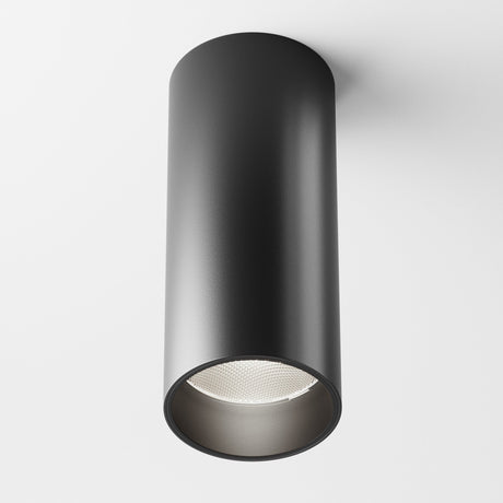 The Focus LED Dimmable Fixed Round Surface Mounted Downlight, 12W 4000K in matte black, is elegantly attached to a white ceiling. The sleek modern cylinder reveals its textured interior as the dimmable LED light remains off.