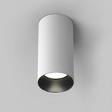 The Artisan Single Fixed Round Surface Mounted Downlight in white boasts a modern cylindrical design and bright bottom emission, seamlessly integrating with plain white ceilings.