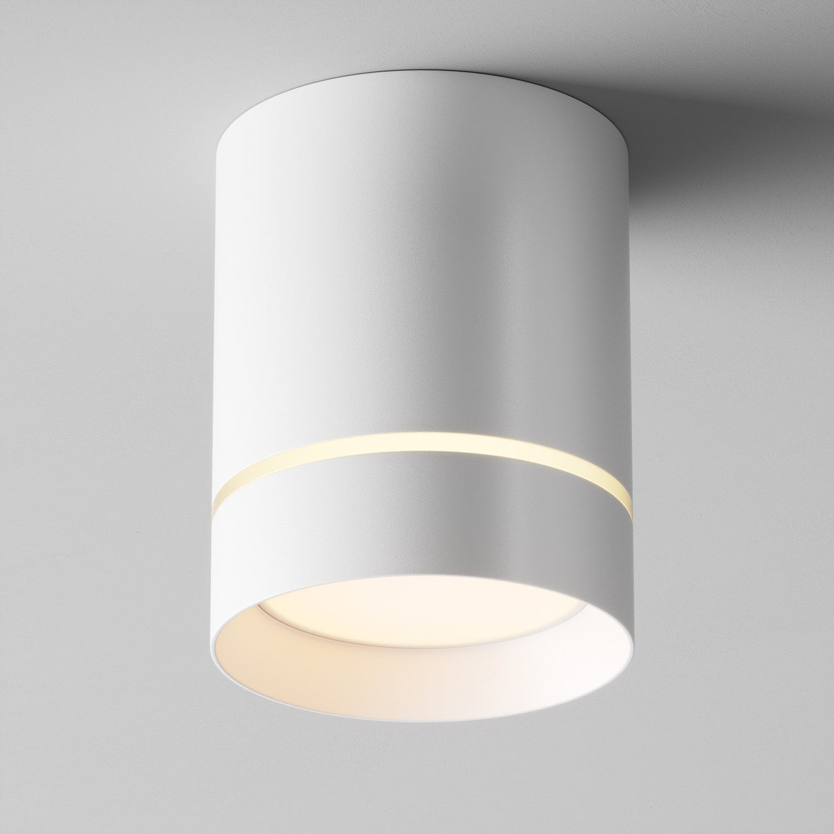 The Orlo LED Round Surface Downlight 9W 3000K in white is a modern ceiling fixture with a minimalist cylindrical design, features a narrow top gap for a soft glow, and complements its main downward light. Its energy-efficient and mounts seamlessly onto a white ceiling.