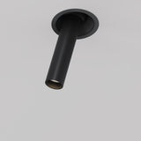 The Focus T LED Adjustable Short Retractable In-Out Recessed Downlight 7W 3000K in black is a contemporary cylindrical ceiling fixture with a sleek design, offering directional lighting from a circular mount on a white ceiling, and features an energy-efficient adjustable LED.