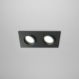 The Atom Twin Tilt Rectangular Recessed Downlight in black features a sleek frame with twin adjustable light heads, perfect for a modern white ceiling.