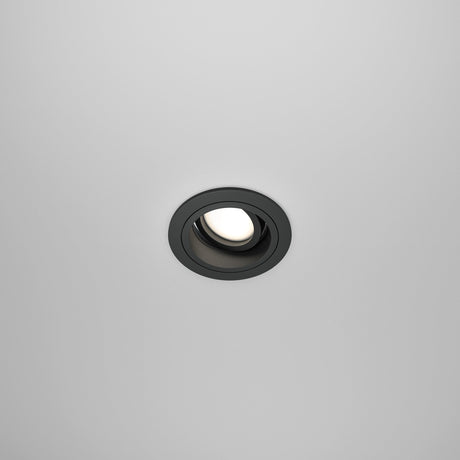 The white ceiling features the Atom Single Tilt Round Recessed Downlight in black, which adds a modern touch. This recessed fixture has an adjustable tilt and emits a soft glow when turned on.