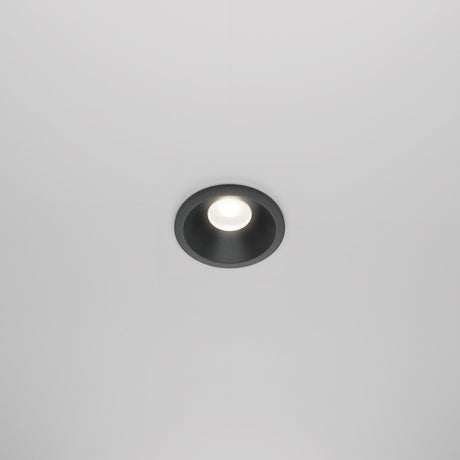 The Zoom LED Round Recessed Downlight 6W 4000K - Black elegantly illuminates a plain white ceiling with its modern design and IP65 rating.