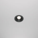 The Zoom LED Dimmable Round Recessed Downlight 6W 4000K in black is a ceiling-mounted light with a circular frame that emits a bright, focused beam. Its minimalist design and IP65 rating make it perfect for versatile environments.