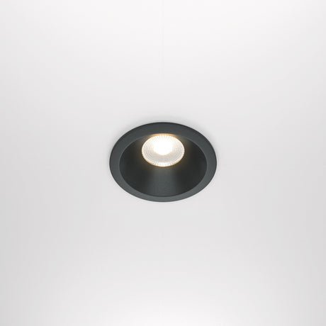 The Zoom LED Dimmable Round Recessed Downlight 12W 3000K - Black softly illuminates with a warm glow and features a black rim against a white background.
