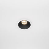 The Alfa LED Dimmable Fixed Round Recessed Downlight 10W 3000K - White & Black casts a warm glow on a plain white ceiling, enhancing the contemporary interior with its modern and sleek design.