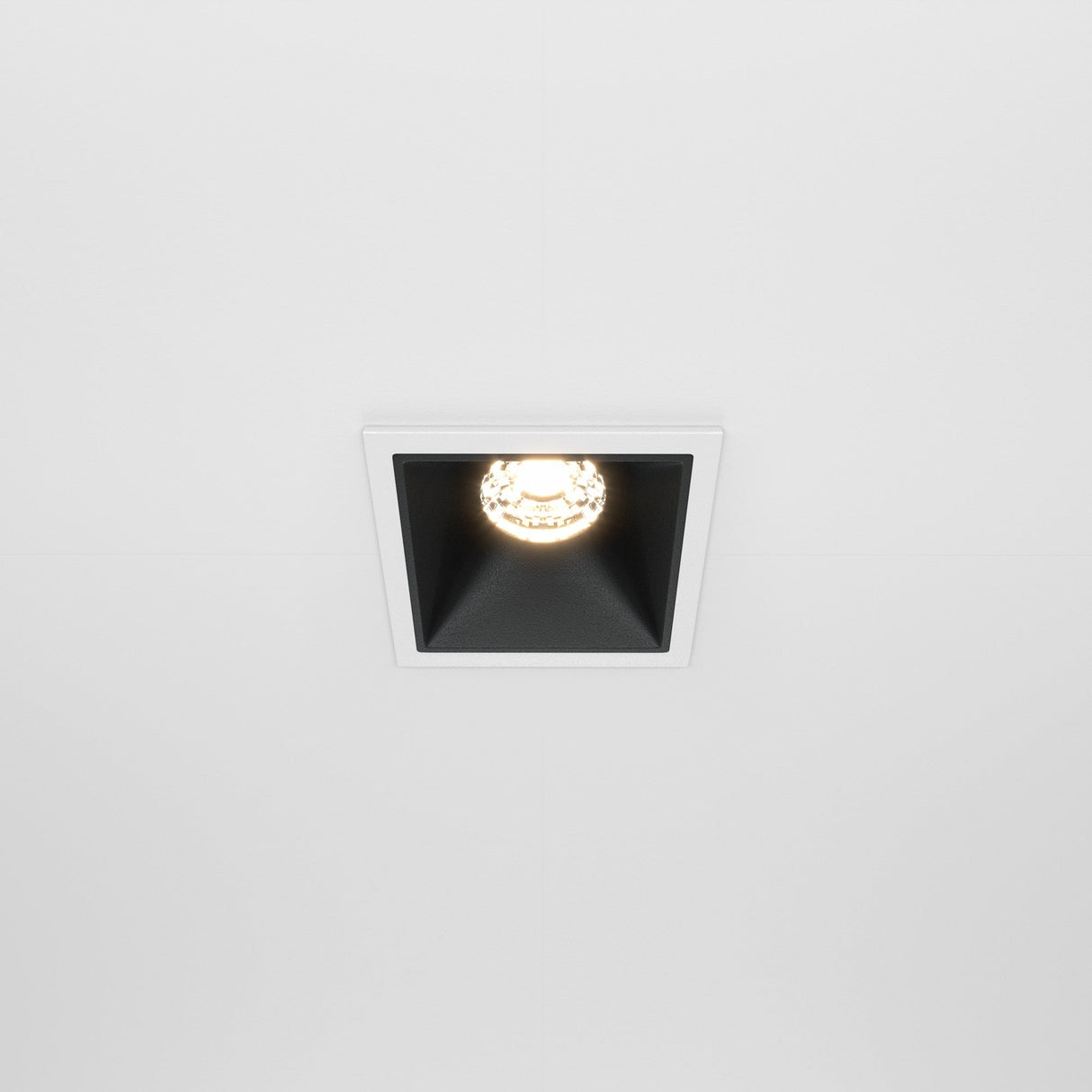 The Alfa LED Fixed Square Recessed Downlight 10W 3000K features a black interior and is installed in a white ceiling, creating a modern two-tone look.