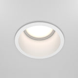 The Reif Round Recessed Downlight - White, crafted from high-quality materials, is installed in a white ceiling and emits soft, bright light ideal for modern spaces.