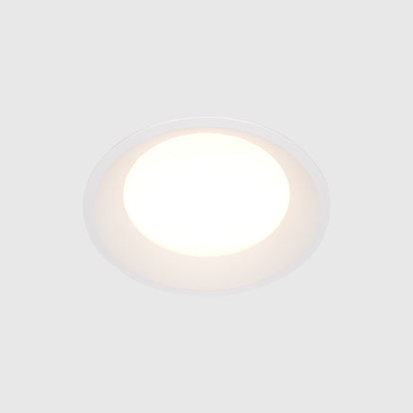 The Okno LED Round Recessed Downlight 18W 4000K, set in a white ceiling, emits a soft glow. This energy-efficient fixture embodies minimalism with its smooth, modern design.