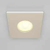 The Stark Fixed Square Recessed Downlight - White features a glowing circular bulb and GU10 bulbs, set against a light gray ceiling.