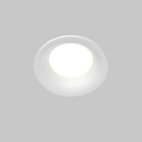 The Slim Outdoor Fixed Round Recessed Downlight - White emits a bright, soft light against a light gray background. Its clean, minimalistic design offers a modern aesthetic and is GU10 bulb compatible for versatile use.