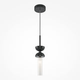 The Kyoto Pendant Light - Black & Black Marble Base features a modern black design with a glossy finish, straight rod, and rounded cover. Its cylindrical bulb elegantly illuminates against a plain white wall, offering customizable lighting for any space.