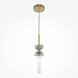 The Kyoto Pendant Light - Gold & Grey Marble Base radiates modern elegance with its sleek gold frame, speckled gray stone accents, and elongated frosted white glass shade. It hangs gracefully from a thin cord against a pristine white backdrop.