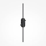 The Renaissance LED Wall Light - Black features a sleek, minimalist design with a sophisticated black finish. Two thin elements emerge from the center, creating a contemporary look against a plain, light background.