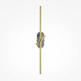 The Renaissance LED Wall Light combines a vertical brass rod and curved accents intersecting a textured grey marble circle, all set against a plain light gray background.