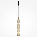The Ordo LED Long Pendant Light features a gold vertically ribbed design with a cognac cylindrical glass shade and black ceiling mount, showcasing an elegant ridged structure that houses an energy-efficient LED light for a contemporary look.